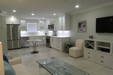 Example of a minimalist porcelain tile and gray floor kitchen design in Other with shaker cabinets, white cabinets, stainless steel appliances and white countertops