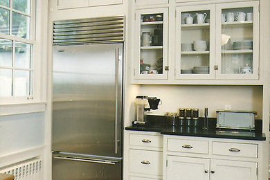 Kitchen - large traditional medium tone wood floor kitchen idea in New York with an undermount sink, recessed-panel cabinets, white cabinets, granite countertops, black backsplash, stone slab backsplash and stainless steel appliances