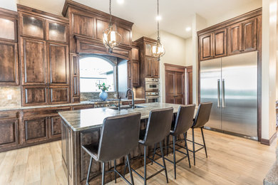 Elegant kitchen photo in Other with raised-panel cabinets, dark wood cabinets and an island