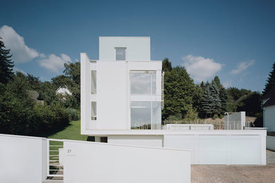 Ejemplo de fachada de casa blanca y blanca minimalista grande de dos plantas con revestimiento de piedra y tejado plano