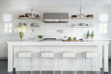 Example of a trendy galley dark wood floor kitchen design in New York with shaker cabinets, white cabinets, white backsplash, subway tile backsplash, stainless steel appliances and an island