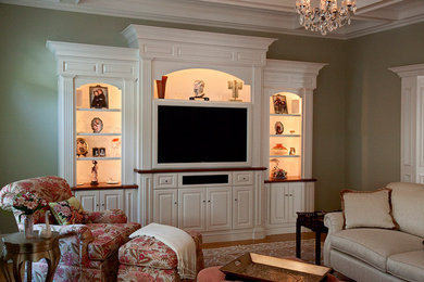 Family room - mid-sized traditional enclosed medium tone wood floor and brown floor family room idea in Boston with green walls and a media wall