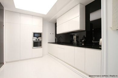 На фото: кухня в современном стиле с белыми фасадами и столешницей из бетона