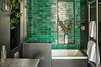 Design ideas for a mid-sized contemporary 3/4 bathroom in London with shaker cabinets, a drop-in tub, a curbless shower, a wall-mount toilet, green tile, cement tile, porcelain floors, marble benchtops, multi-coloured floor, white benchtops, black cabinets, black walls, an undermount sink and an open shower.