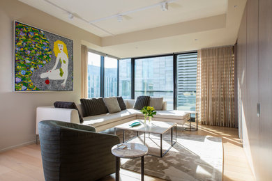 Inspiration for a small contemporary open concept light wood floor living room remodel in DC Metro with beige walls and a concealed tv
