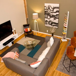 Foto på ett mellanstort funkis loftrum, med flerfärgade väggar, ljust trägolv och en fristående TV