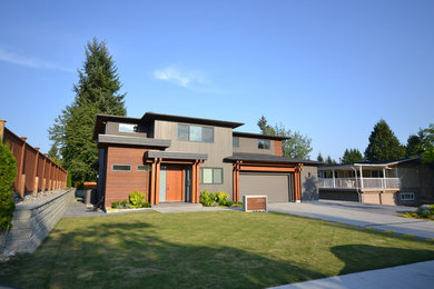 Design ideas for a large contemporary two-storey grey house exterior in Vancouver with mixed siding, a flat roof and a shingle roof.