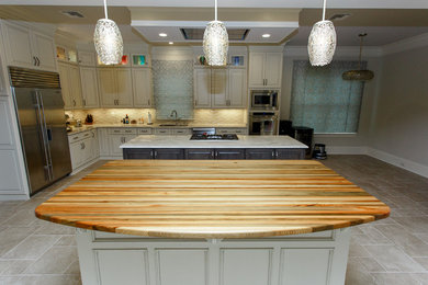 Eat-in kitchen - large contemporary ceramic tile and white floor eat-in kitchen idea in New Orleans with an undermount sink, beaded inset cabinets, white cabinets, wood countertops, stainless steel appliances, an island and green countertops