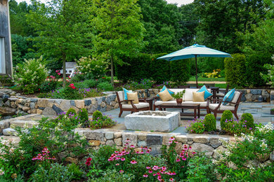 Inspiration for a mid-sized country backyard patio in Boston with a fire feature and natural stone pavers.