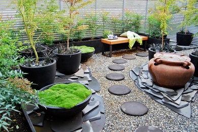 Small asian courtyard shaded formal garden in Canberra - Queanbeyan with a container garden and gravel.
