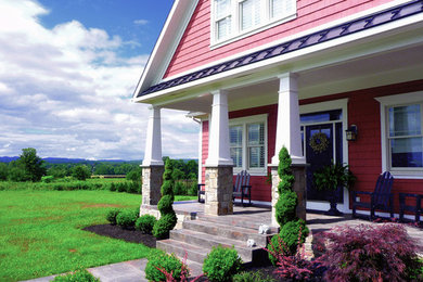 This is an example of a mid-sized traditional stamped concrete front porch design in Philadelphia with a roof extension.