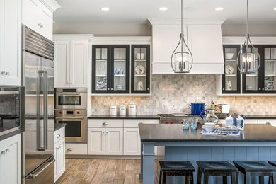 Inspiration for a mid-sized beach style l-shaped eat-in kitchen in Chicago with shaker cabinets, white cabinets, soapstone benchtops, grey splashback, marble splashback, stainless steel appliances, dark hardwood floors, with island and beige floor.