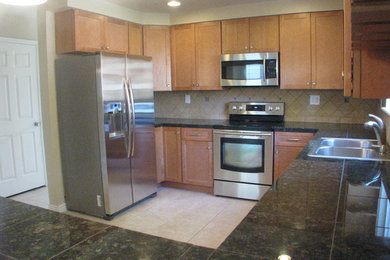 Elegant u-shaped eat-in kitchen photo in Denver with a drop-in sink, flat-panel cabinets, brown cabinets, granite countertops, beige backsplash, porcelain backsplash and stainless steel appliances