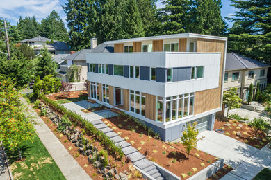Example of a large minimalist multicolored three-story wood exterior home design in Seattle with a mixed material roof