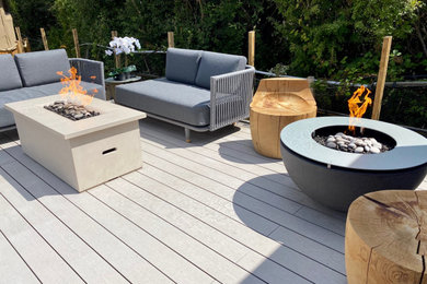 This is an example of a small contemporary backyard full sun garden in Surrey with a fire feature and decking.
