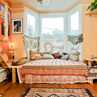 Idées déco pour une chambre éclectique avec un mur orange et un sol orange.