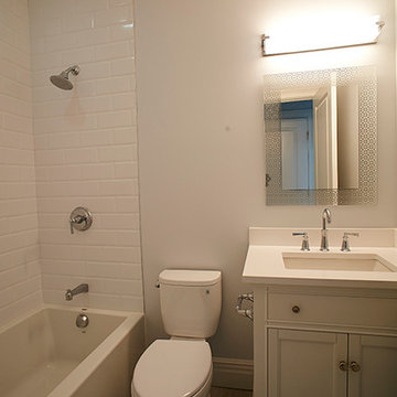 Modern White-Tiled Bathroom with Tub, Shower, and Vanity