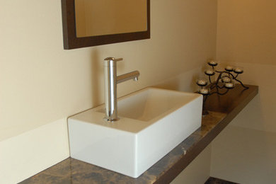 Example of a small minimalist marble floor powder room design in Seattle with medium tone wood cabinets