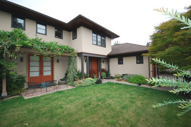 Large trendy beige two-story stucco exterior home photo in Seattle