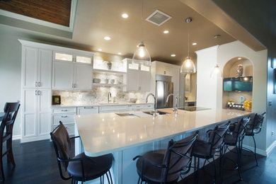 Inspiration for a large transitional galley dark wood floor and brown floor eat-in kitchen remodel in Denver with an undermount sink, shaker cabinets, white cabinets, gray backsplash, stone tile backsplash, stainless steel appliances and a peninsula