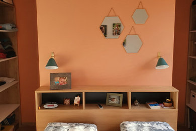Inspiration pour une petite chambre parentale design avec un mur orange, sol en stratifié et un sol marron.