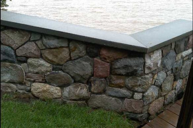 Design ideas for a large transitional full sun backyard retaining wall landscape in New York.