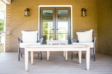 Example of a mid-sized transitional backyard deck design in Orange County with a roof extension