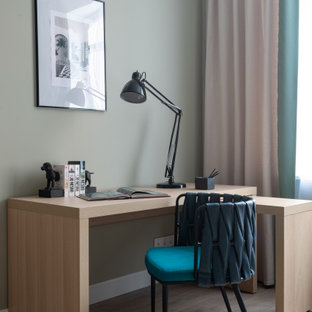 Idéer för ett modernt hemmabibliotek, med laminatgolv, ett fristående skrivbord, grå väggar och beiget golv