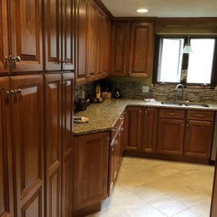 На фото: п-образная кухня среднего размера в классическом стиле с кладовкой, фасадами с выступающей филенкой, фасадами цвета дерева среднего тона, столешницей из гранита, коричневым фартуком, техникой из нержавеющей стали, полом из терраццо и полуостровом с