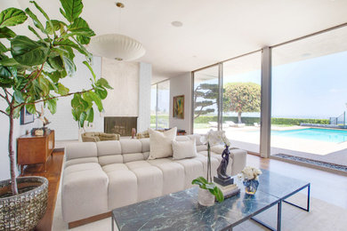 Inspiration for a mid-sized 1960s open concept beige floor living room remodel in Phoenix with white walls, a standard fireplace and a brick fireplace