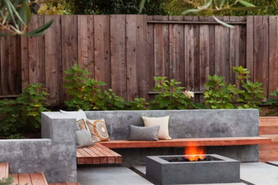 Patio - small modern backyard concrete paver patio idea in Los Angeles with a fire pit and no cover