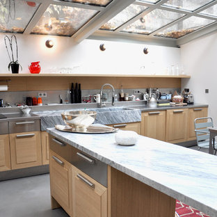 Diseño de cocina comedor en L, actual, grande, con fregadero sobremueble, armarios con paneles con relieve, puertas de armario de madera clara y una isla