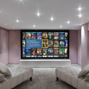This is an example of a small contemporary enclosed home cinema in London with pink walls, carpet and a projector screen.