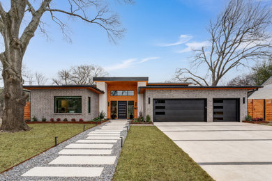 Foto de fachada de casa gris actual de tamaño medio de una planta con tejado plano y revestimientos combinados