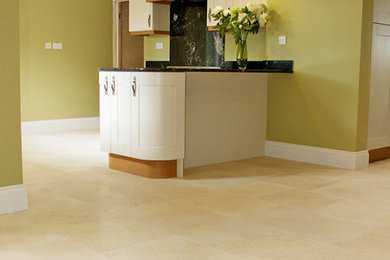 Photo of a medium sized modern u-shaped open plan kitchen in Other with a double-bowl sink, recessed-panel cabinets, white cabinets, limestone worktops, black splashback, stone slab splashback, black appliances, limestone flooring and no island.