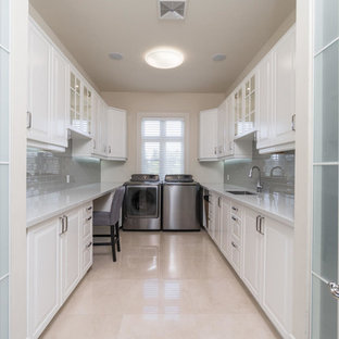 Medium sized contemporary u-shaped utility room in Toronto with a submerged sink, recessed-panel cabinets, white cabinets, granite worktops, grey walls, marble flooring, a side by side washer and dryer and beige floors.