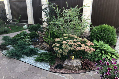 На фото: маленький летний засухоустойчивый сад на переднем дворе в средиземноморском стиле с камнем в ландшафтном дизайне и полуденной тенью для на участке и в саду