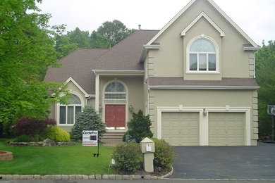 Example of a classic green two-story stucco exterior home design in New York