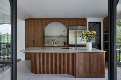 Mid-sized midcentury l-shaped eat-in kitchen in Sydney with an undermount sink, shaker cabinets, medium wood cabinets, quartzite benchtops, beige splashback, marble splashback, black appliances, limestone floors, with island, beige floor and beige benchtop.