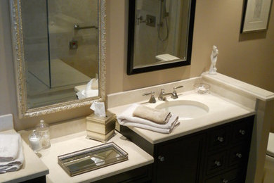 Inspiration for a timeless beige tile and porcelain tile linoleum floor bathroom remodel in New York with raised-panel cabinets, medium tone wood cabinets, beige walls and laminate countertops