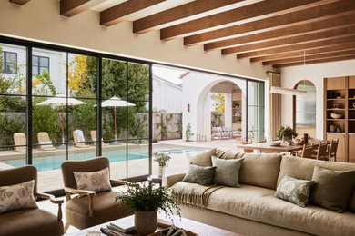 Mediterranes Wohnzimmer mit beiger Wandfarbe und freigelegten Dachbalken in Orange County