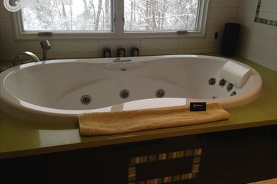 Bathroom - mid-sized modern green tile bathroom idea in New York with an undermount tub