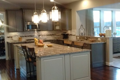 Inspiration for a mid-sized transitional l-shaped medium tone wood floor and red floor eat-in kitchen remodel in Other with an undermount sink, raised-panel cabinets, gray cabinets, granite countertops, multicolored backsplash, subway tile backsplash, stainless steel appliances, an island and multicolored countertops