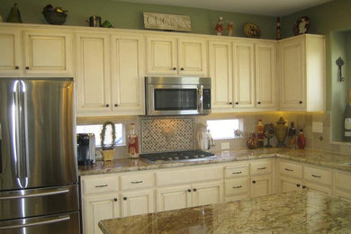 Eat-in kitchen - mid-sized country u-shaped eat-in kitchen idea in San Francisco with a double-bowl sink, raised-panel cabinets, white cabinets, granite countertops, stone tile backsplash, stainless steel appliances and an island