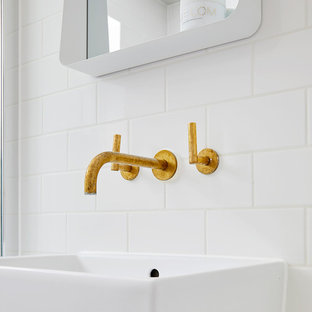 Design ideas for a small modern family bathroom in London with flat-panel cabinets, dark wood cabinets, a built-in bath, a shower/bath combination, a one-piece toilet, white tiles, ceramic tiles, white walls, cement flooring, a trough sink, quartz worktops, multi-coloured floors and a hinged door.