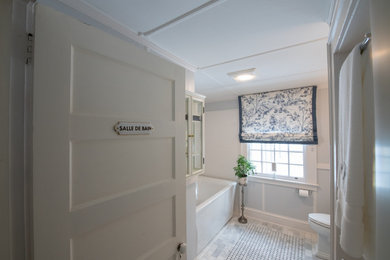 Badezimmer mit freistehender Badewanne, Wandtoilette mit Spülkasten, Marmorboden, Waschtischkonsole und Einzelwaschbecken in Bridgeport