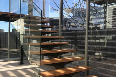 Design ideas for a contemporary wood floating staircase in Perth with glass railing.