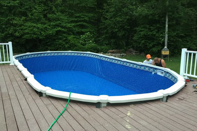 Oval above ground swimming pool replacement with a large wooden deck to work off