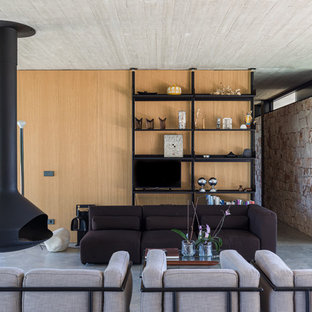 Idéer för att renovera ett funkis vardagsrum, med bruna väggar, betonggolv, en hängande öppen spis, en fristående TV och grått golv