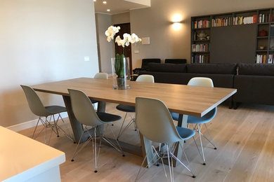 Cette photo montre une salle à manger ouverte sur le salon tendance de taille moyenne avec un mur gris, parquet clair et un sol beige.